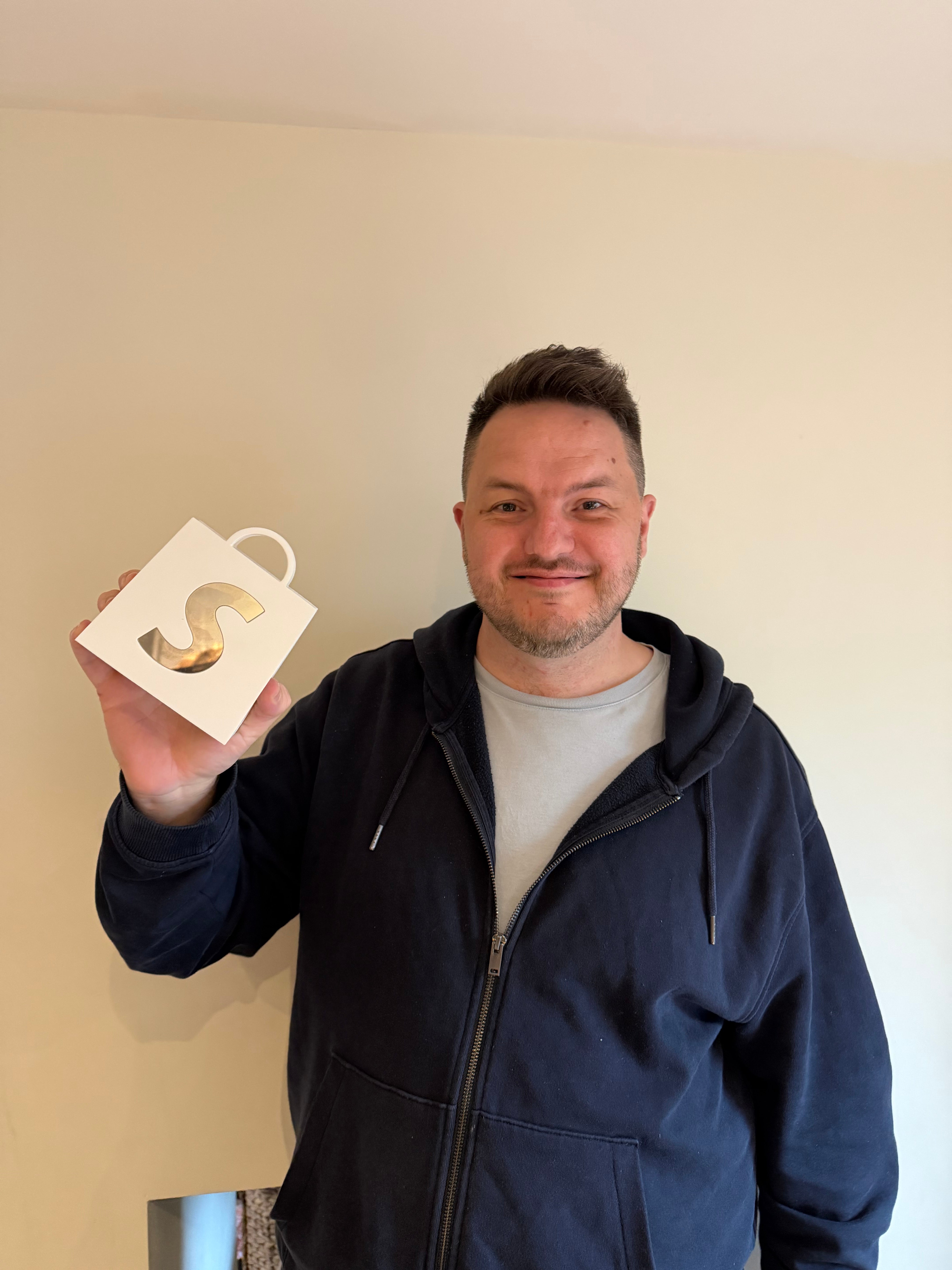 Dean Keating holding his Shopify award